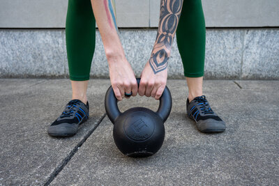 a person holding a kettlebell in the hike position to demonstrate your strength journey