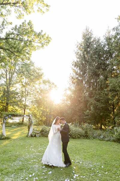 Bride and groom share first dance during sunset during their small intimate london ontario cottage wedding
