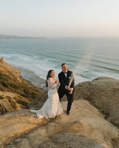bride and groom on ocean cliff