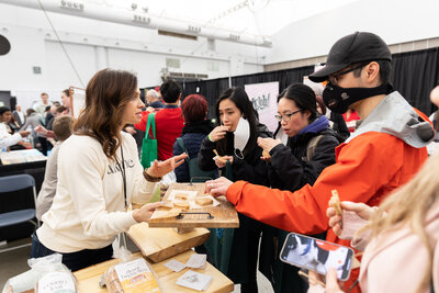 Alkeme founder Melinda Kopet engaging with a lineup of expo attendees curious about gluten-free sourdough.