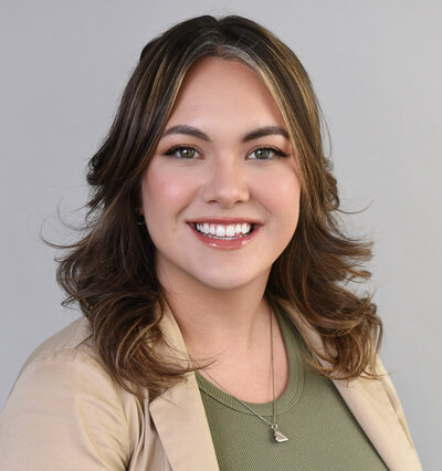 Studio professional headshot of young woman wearing green shirt