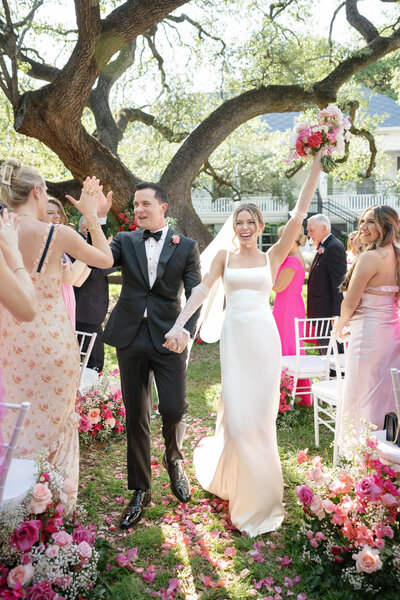 groom and blonde bride in white wedding dress and pink flowers