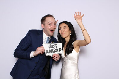 Couple using photo booth props at their wedding reception