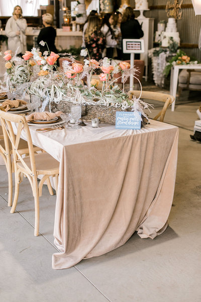 wedding reception table decorated with pink flowers and dishes