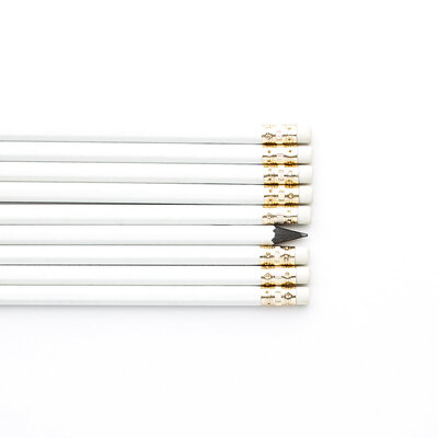 A row of white pencils on a white table
