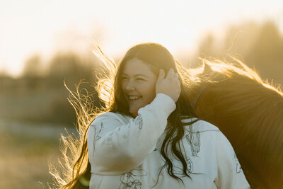 a girl at sunset with her horse