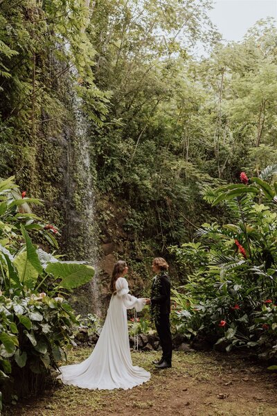 bride and groom saying vows under a waterfall