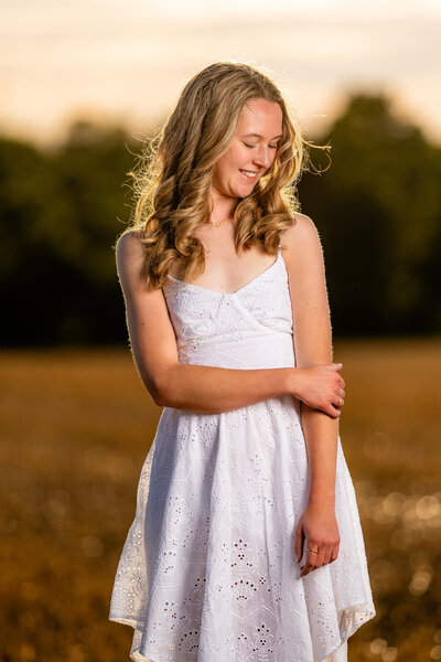 natural light senior portrait of a senior laughing in a park surrounding by trees near Sewickley PA. Captured by Michael Fricke Photography, a senior portrait photographer.