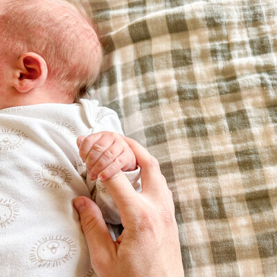 Baby holding mom's finger.
