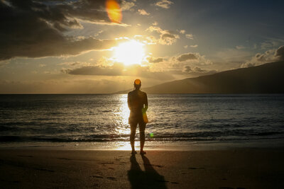 Girl standing at a beach sunset
