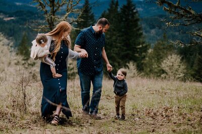 Family of four walking together in the trees.