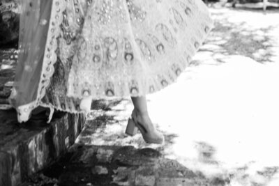 Bride and groom walking hand-in-hand under a stone archway