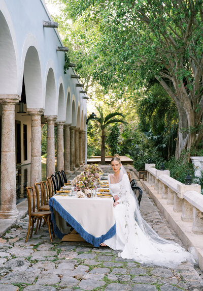 Stunning bride sits at wedding reception table at Chable Yucatan wedding venue