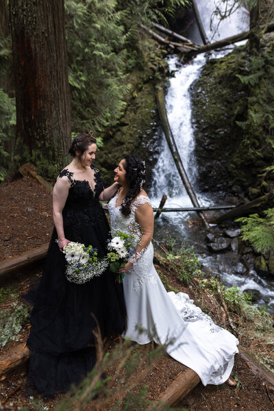 Two brides looking lovingly at each other on their Olympic National Park elopement day.