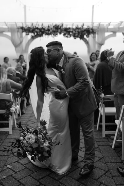 bride and groom kissing while bride holds wedding bouquet