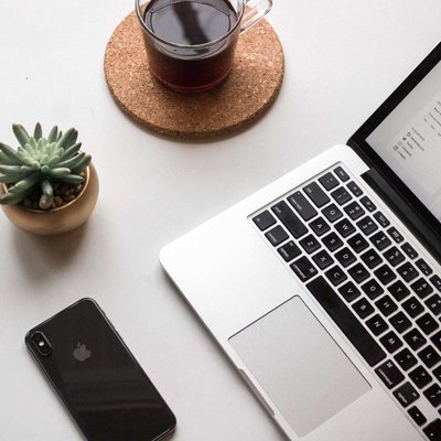 Desk flatlay with laptop, iPhone, coffee and succulent plant