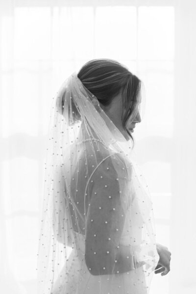 Bride with a soft low bun styled for veil placement — classic wedding hairstyle by Klover Beauty for Maryland brides.