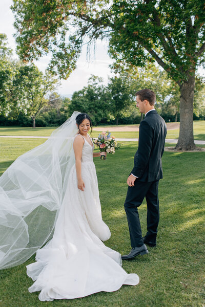 Bride and Groom walk together as they celebrate their first moments married. Bride is carrying a pastel wedding bouquet. Photo by Anna Brace, an Omaha Wedding Photographer