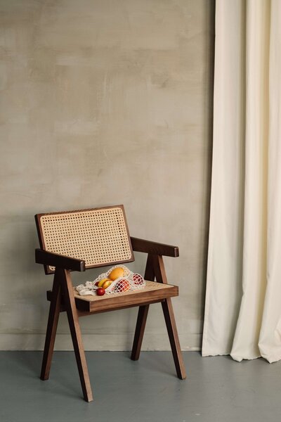 Entrance to West Vancouver renovation with plaster walls, linen drapery, and modern wooden chair