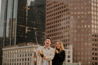 man and woman popping champagne