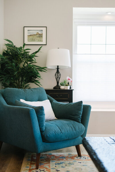 Teal chair in a living room of a realty listing