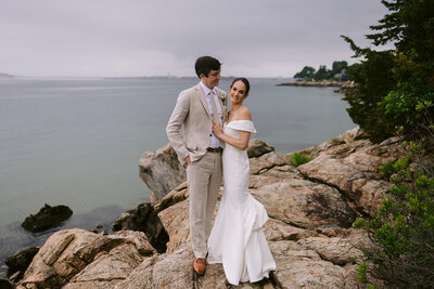 Wedding couple pose on cliffside at Misselwood in Beverly, MA