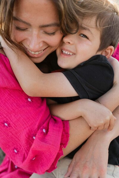 Mom tenderly embracing son at sunset during Cleveland family photography session.