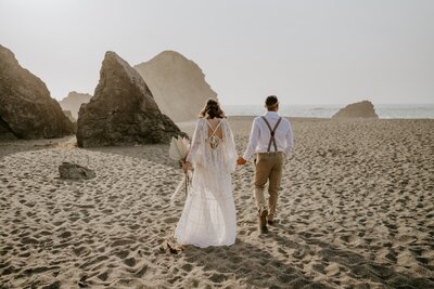 couple walk on beach during northern california elopement in jenner