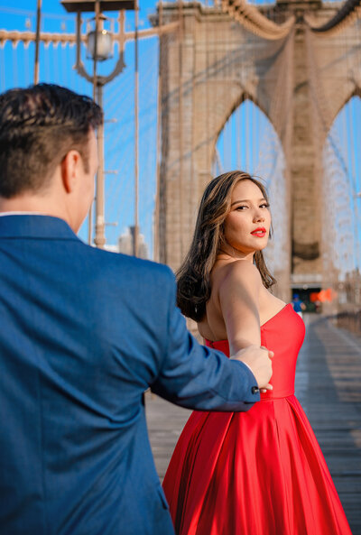 brooklyn bridge couple walking in elegant red dress