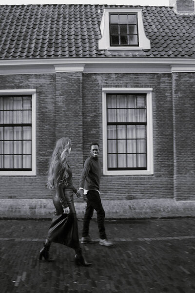 Koppel wandelt over straat in Nederlands dorp, gefotografeerd door fotograaf Julia de Groot