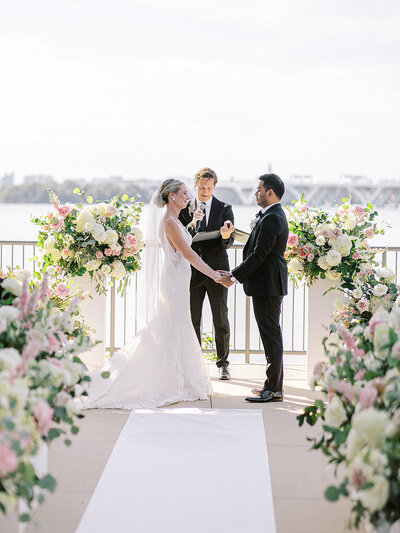 Bride and groom holding hands under umbrella at Silverbrook Farm captured by Virginia Wedding Photographer Sarah Botta Photography