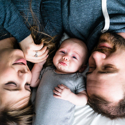 pouty lipped newborn snuggled between parents, Lynnwood | Meg Sivakumar Photography
