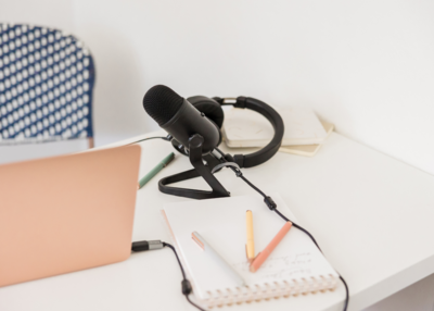 Close-up of podcast recording equipment, including a microphone and laptop, representing Vanessa's readiness for digital interviews.