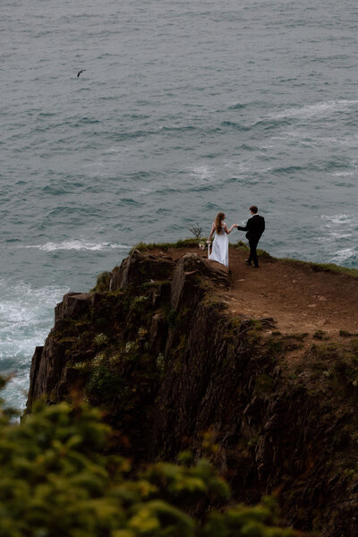 Bride spinning while groom holds her hand on the Oregon Coast.