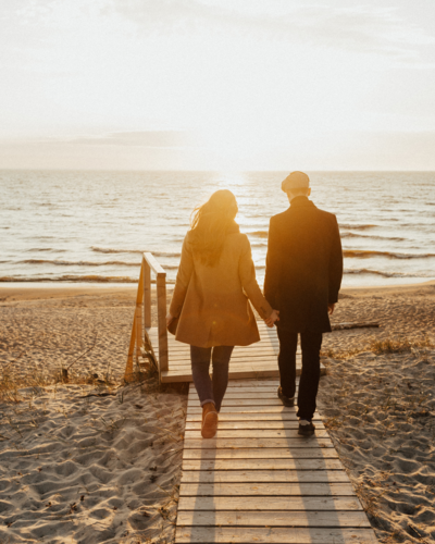 couple holding hands walking towards beach healing mindfulness peaceful conflict resolution