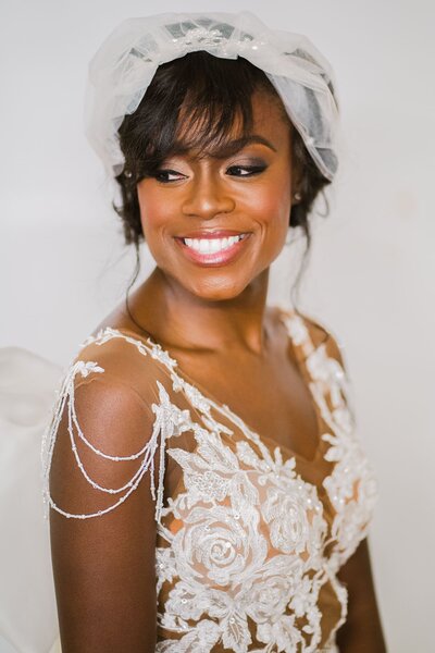 A bride looking over her shoulder smiling.
