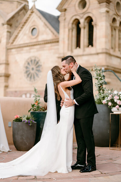 Bride and Groom kissing with cathedral in background