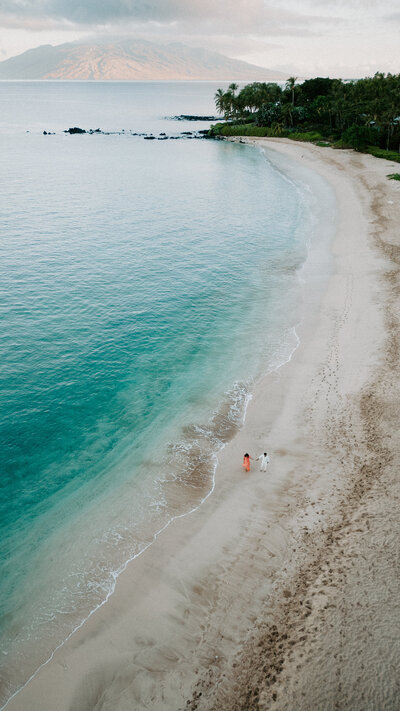 Hawaii Engagement Photographer captures couple walking hand in hand on beach