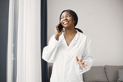 A female dentist smiling while talking on the phone.