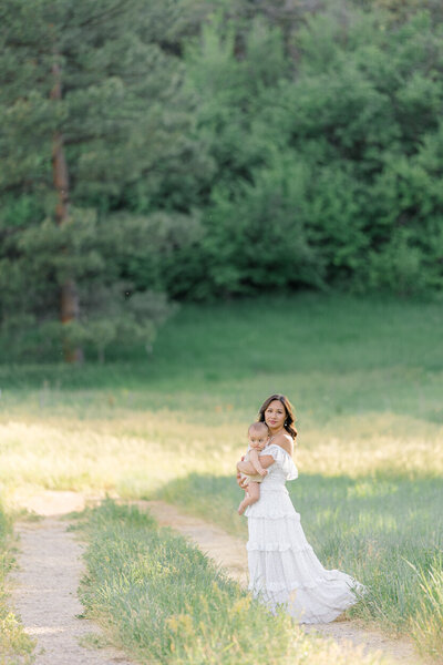 mom holding baby in field