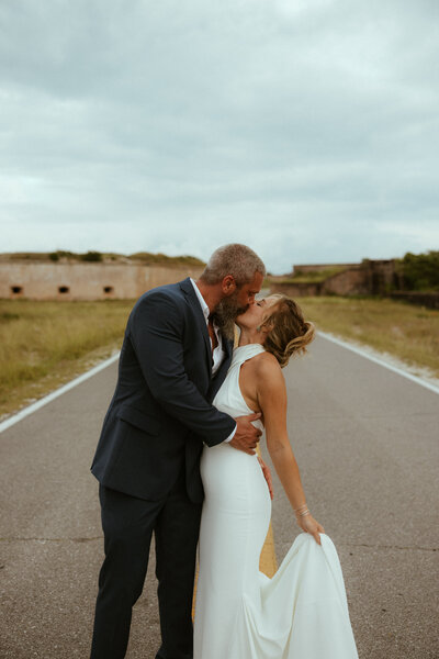 wedding couple kissing in the road.