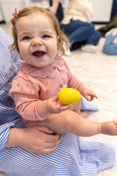 Baby smiling holding a toy egg