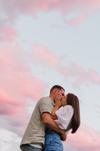 Couple kissing against a gorgeous colorado sunset 