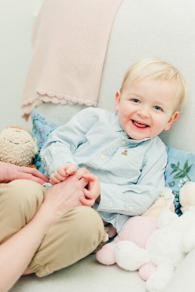 Adorable toddler boy on a brick path happy and smiling for his Richmond family photographer