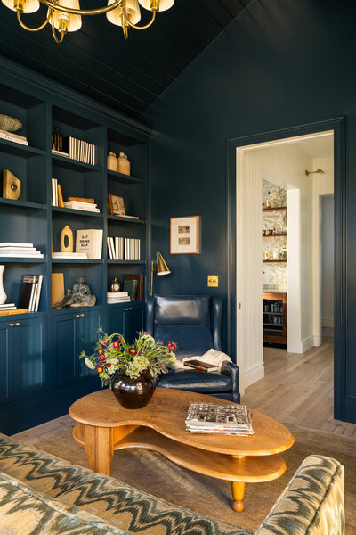 Teal blue dining room side board with bold wallpaper and barware