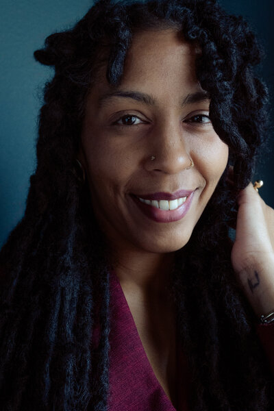 A sophisticated black-and-white portrait of photographer Nerissa James, capturing her confident and thoughtful expression.