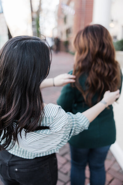 stylist adjusting a woman's rich brown brunette styled hair