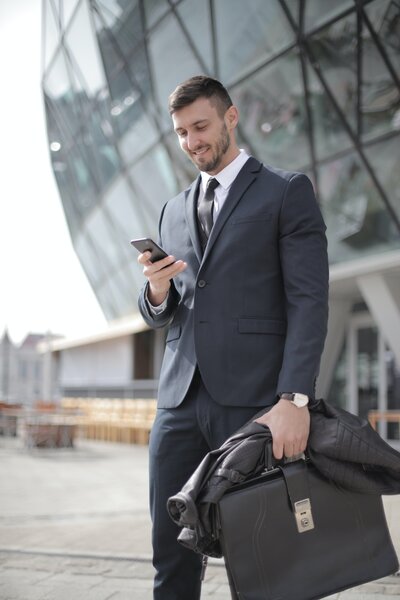 Man in a grey suit looking at a phone