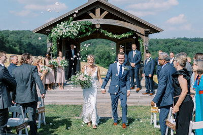 Bride laughs with her bridesmaids in colorful dresses with stunning colorful flowers at Delaware Wedding