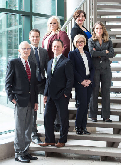 a group of corporate business people in suits standing on stairs for their group photo.  Capture indoors by Ottawa Commercial Photographer JEMMAN Photography
